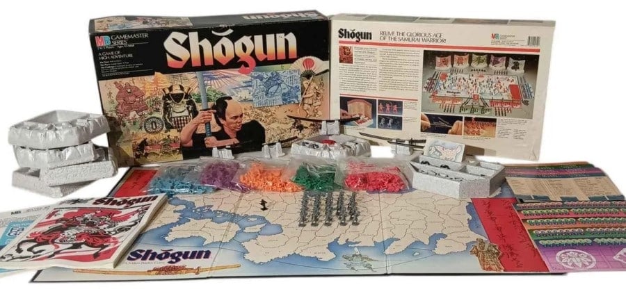 A screenshot of the game box of Shogun with various maps, miniatures, and sheets on a white background.