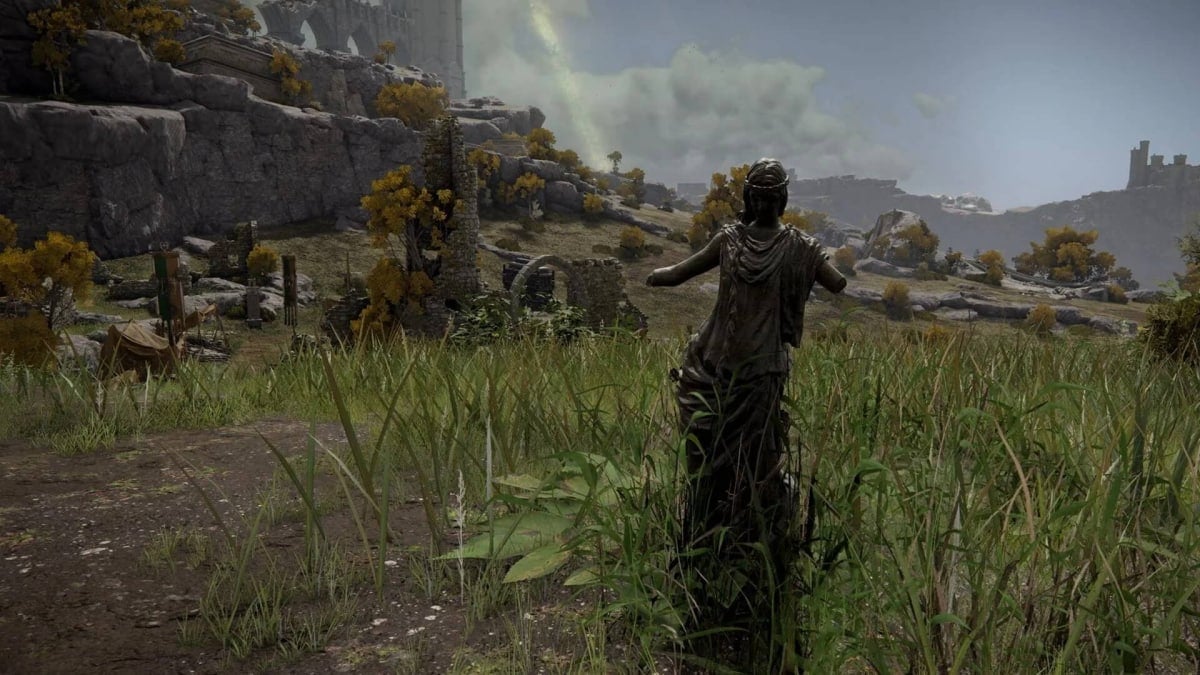 A statue of a woman with arms missing in a field.