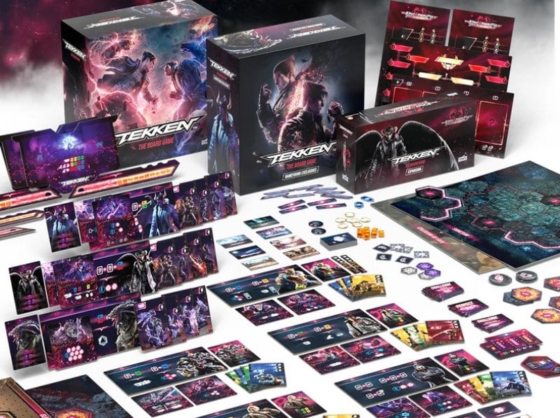 A display of boards, cards, dice, and boxes on a white background.