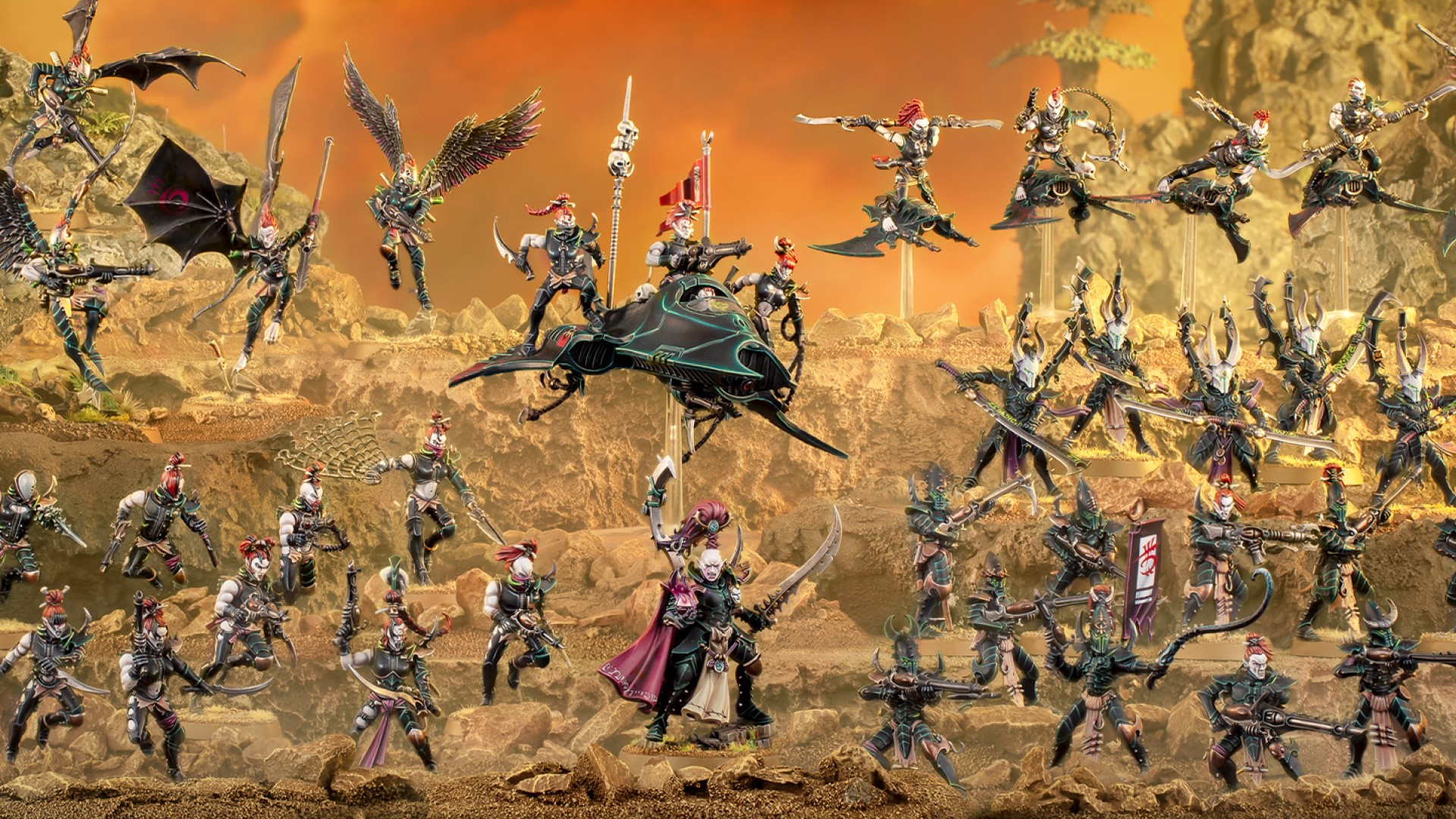 Three rows of drukhari miniatures on a layered sandy mound.